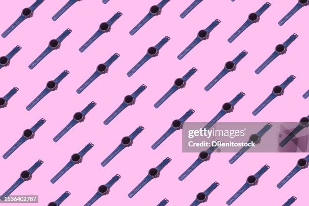 pattern of smartwatches wristwatches with digital screen and green plastic strap on pink background. concept of time, stopwatch, gps, measure, passage of time, past, present and future. - luxusuhr stock-fotos und bilder