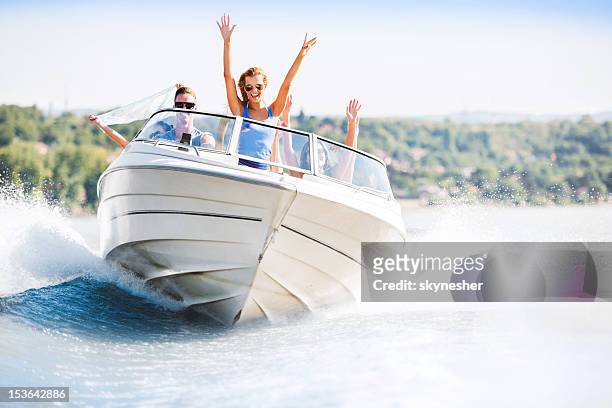 alegre joven montando en un bote - lago fotografías e imágenes de stock