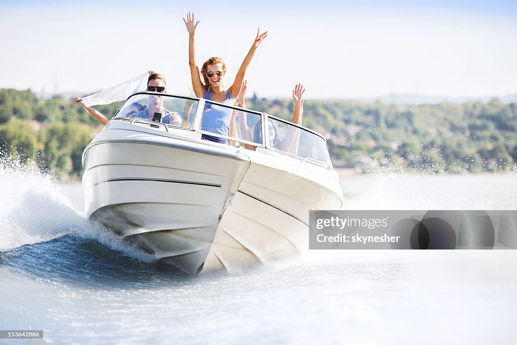 Cheerful young people riding in a speedboat