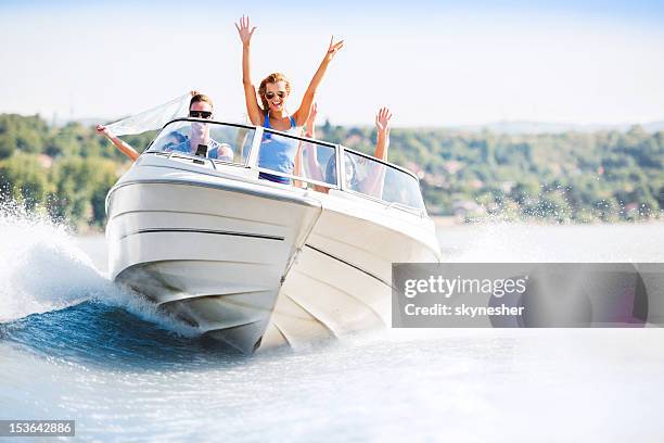 cheerful young people riding in a speedboat - lake boat stock pictures, royalty-free photos & images