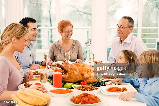 extended family having thanksgiving dinner. - big family dinner stock pictures, royalty-free photos & images