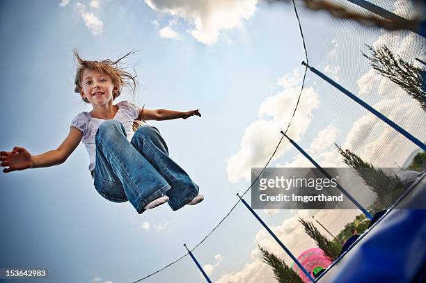 trampolin vergnügen - girl jumping stock-fotos und bilder