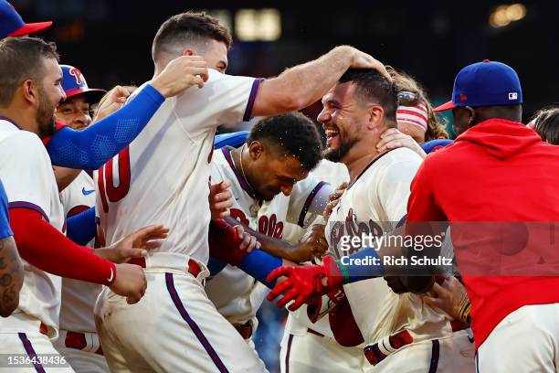 Kyle Schwarber of the Philadelphia Phillies is mobbed by J.T. Realmuto, Johan Rojas and the rest of his teammates after hitting an RBI single in the...
