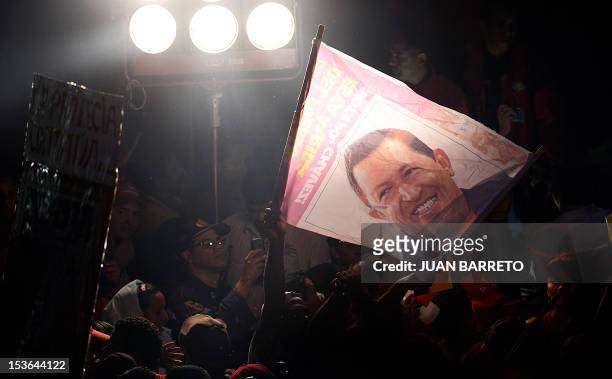 Supporters of Venezuelan President Hugo Chavez celebrate after receiving news of his reelection in Caracas on October 7, 2012. According to the...