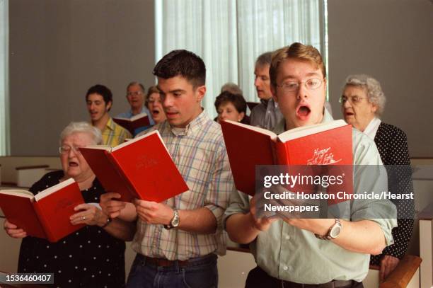 David Sinden, Joshua Lawrence, and Pat Wickey sing from "The Hymnal of Truth and Light" during a service of the First Congregational Church of...