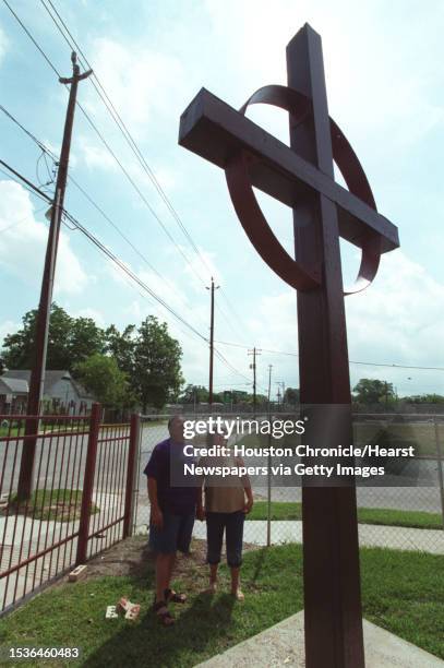 Robert Armendariz, Treasurer and Esther Ruth Flores, Clerk of Session for Juan Marcos Presbyterian Church look at the cross in front of the church....