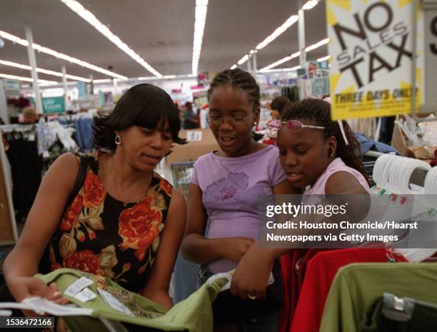 Shelia Leath looks at clothes for her daughter, Brittney Leath as a friend, Charissa Johnson, also offers her opinion. They were taking advantage of...