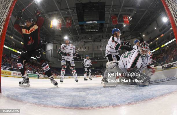 Andre Reiss of Hannover celebrates after he scores his team's 2nd goal over Patrick Ehelechner , goaltender of Augsburg during the DEL match between...