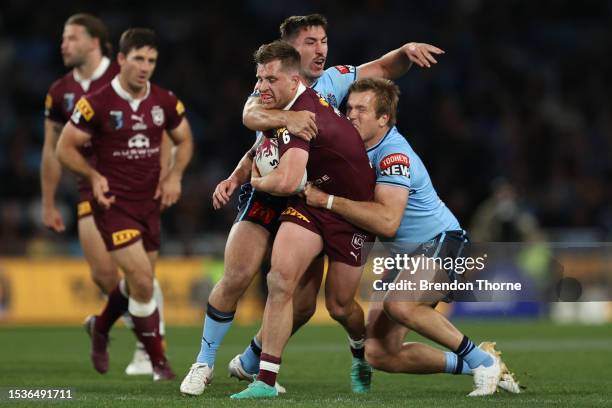 Cameron Munster of the Maroons is tackled by Reece Robson and Jake Trbojevic of the Blues during game three of the State of Origin series between New...