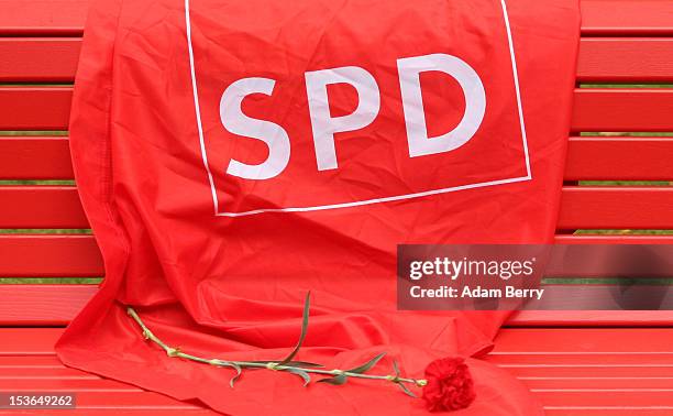 Flag with the logo of the German Social Democrats and a rose lay on a bench near the grave of Willy Brandt, former chancellor of the Federal Republic...