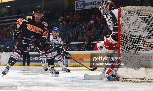 Andre Reiss of Hannover skates in front of Patrick Ehelechner , goaltender of Augsburg during the DEL match between Hannover Scorpions and Augsburger...