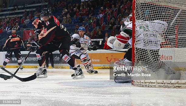 Andre Reiss of Hannover skates in front of Patrick Ehelechner , goaltender of Augsburg during the DEL match between Hannover Scorpions and Augsburger...