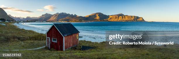 red cabin overlooking the cold arctic sea - mar da noruega - fotografias e filmes do acervo