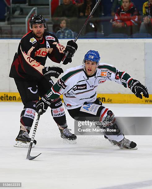 Gerrit Fauser of Hannover and Sergio Somma of Augsburg battle for the puck during the DEL match between Hannover Scorpions and Augsburger Panther at...