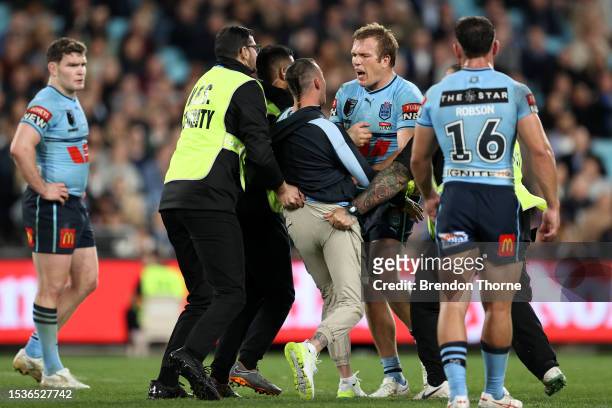 Jake Trbojevic of the Blues confronts a pitch invader during game three of the State of Origin series between New South Wales Blues and Queensland...