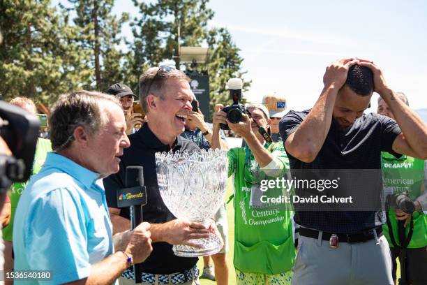 Golden State Warrior Stephen Curry is presented with the ACC Golf Championship trophy by Jonathan Thomas, president and chief executive officer of...