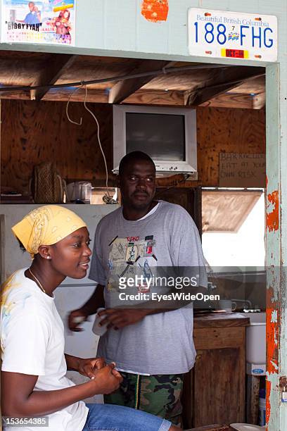 Young local bahamian woman and a man at a foodstall at New Bight Beach on June 15, 2012 in Cat Island, The Bahamas.