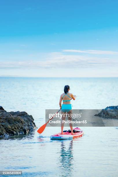 asian athletic woman on paddle board at the sea. solo outdoor water sport and travel on summer holiday thailand. - wildlife reserve stock pictures, royalty-free photos & images