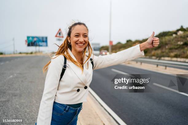 junge frau trampt auf einer autobahn in malta - malta wandern stock-fotos und bilder