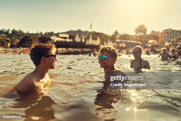 teenagers playing on in the sea in liguria, italy - crowded beach stock pictures, royalty-free photos & images