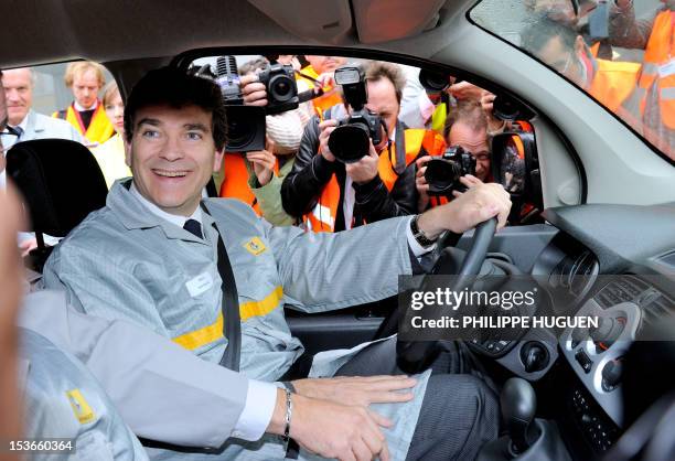 French Minister for Industrial Renewal Arnaud Montebourg sits in a Renault ZE electric car as he visits the plant of the French carmaker on October...