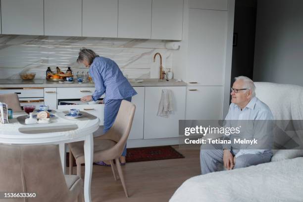 quiet life in old age, there is happiness. grandfather stands at the window waiting - granny flat stock pictures, royalty-free photos & images