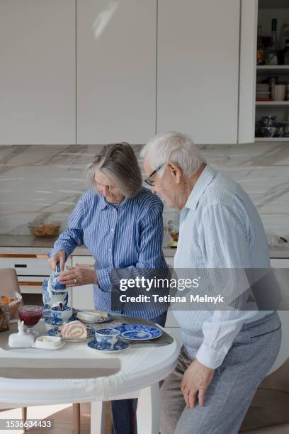 quiet life in old age, there is happiness. grandfather stands at the window waiting - granny flat stock pictures, royalty-free photos & images