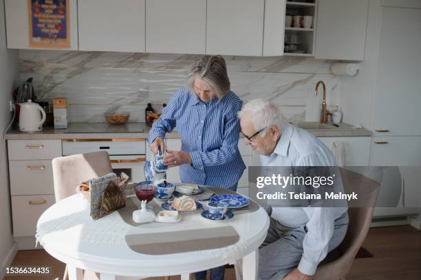 quiet life in old age, there is happiness. grandfather stands at the window waiting - granny flat stock pictures, royalty-free photos & images