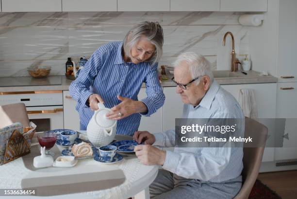 quiet life in old age, there is happiness. grandfather stands at the window waiting - granny flat stock pictures, royalty-free photos & images