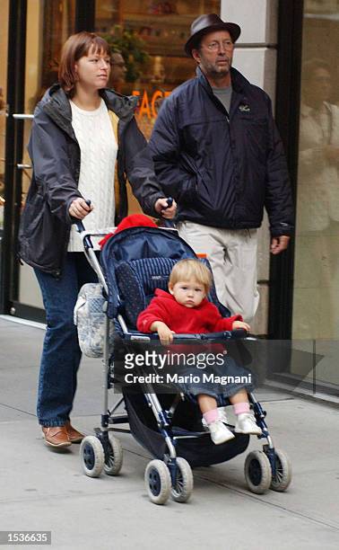 Musician and song writer Eric Clapton walks with wife Melia McEnery and their baby Julie Rose Clapton while shopping on Madison Avenue October 28,...