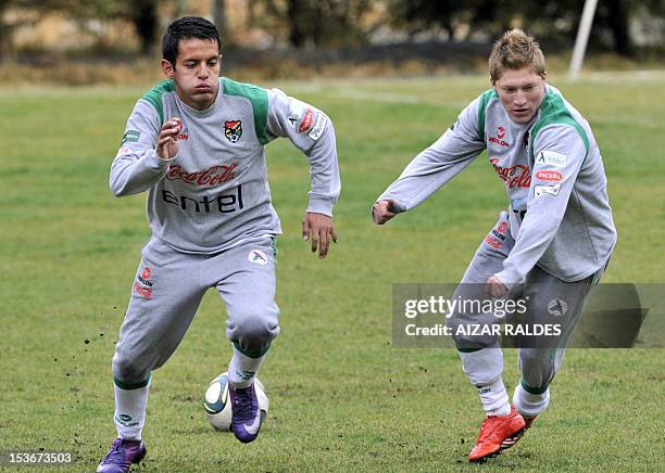 Bolivia's national football players Jhasmani Campos and Alejandro Chumacero make exercises during a training session in La Paz on October 8, 2012....