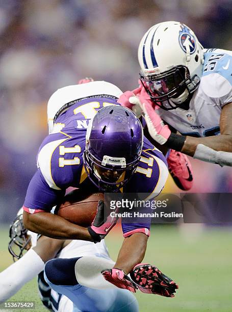 Akeem Ayers of the Tennessee Titans tackles Stephen Burton of the Minnesota Vikings during the game on October 7, 2012 at Mall of America Field at...
