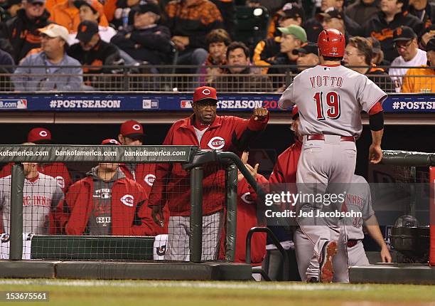 Joey Votto of the Cincinnati Reds celebrates with manager Dusty Baker after scoring in Game 2 of the NLDS against the San Francisco Giants at AT&T...