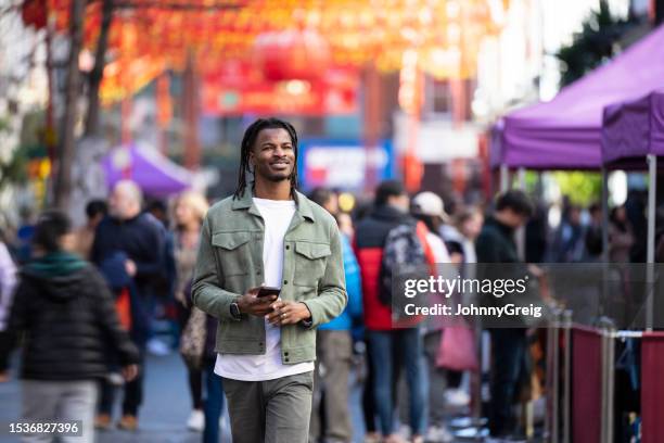 urban vacationer walking through chinatown in london - walker stock pictures, royalty-free photos & images