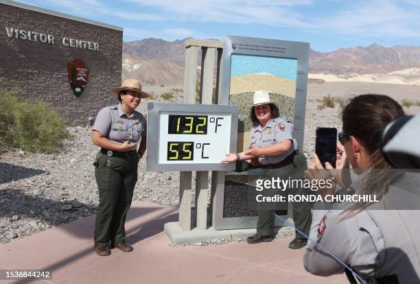 National Park Service Rangers Gia Ponce and Christina Caparelli are photographed by Ranger Nicole Bernard next to a digital display of an unofficial...