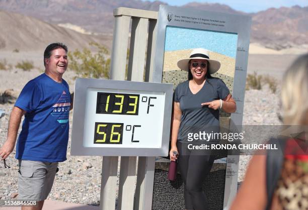 Clint Johnson, of Pleasant Hill, Calif., and Melanie Anguay, of Las Vegas, stand for a photo next to a digital display of an unofficial heat reading...