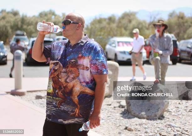 Shaun Slack, of Rhinelander, Wisconsin, takes a drink of water outside Furnace Creek Visitor Center during a heat wave in Death Valley National Park...