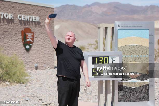 Scott Hughes, of Swansea, Wales, UK, takes a selfie next to a digital display of an unofficial heat reading at Furnace Creek Visitor Center during a...