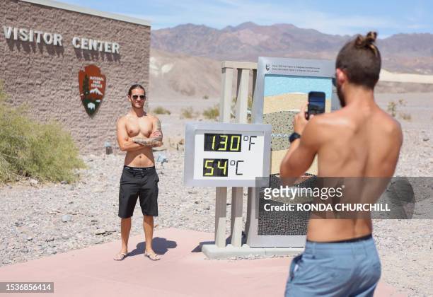 Gabriel Ambrus de Moraes is photographed by his twin brother Pedro, both of Los Angeles, as he stands next to a digital display of an unofficial heat...