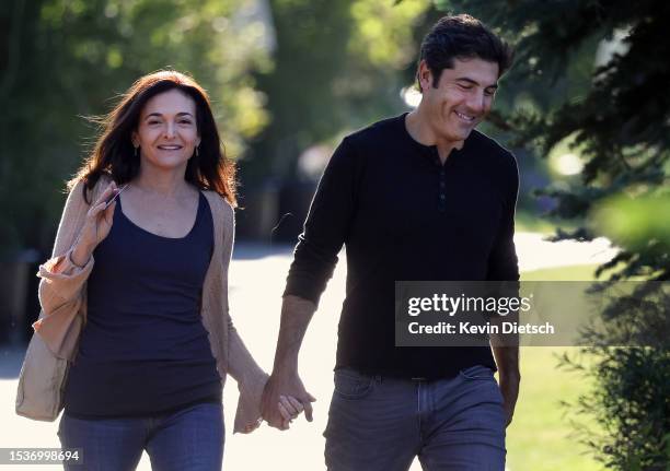 Sheryl Sandberg, COO of Meta Platforms, and her husband Tom Bernthal walk to a morning session at the Allen & Company Sun Valley Conference on July...