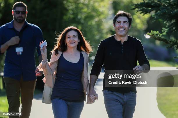 Sheryl Sandberg, COO of Meta Platforms, and her husband Tom Bernthal walk to a morning session at the Allen & Company Sun Valley Conference on July...