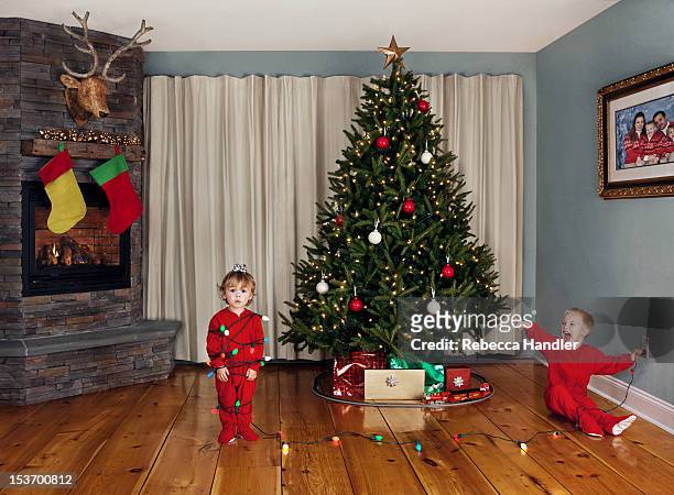 two young children wrapped in christmas lights - ragazzo new york foto e immagini stock
