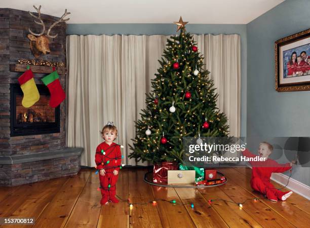 two young children wrapped in christmas lights - real christmas tree stock pictures, royalty-free photos & images