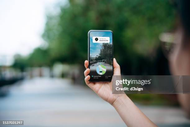 close up of a woman holding smartphone using an augmented reality application to search for direction to the destination in city street. following the navigation route with gps navigation map device. technology and geolocation concept - following map stock pictures, royalty-free photos & images