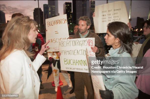 Protesters hold up signs attacking GOP presidential candidate Pat Buchanan and his stance on abortion Saturday night outside the George R. Brown...