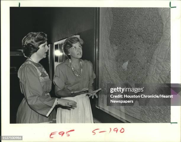 Jane Thompson, left, praises Carol Strittmatter's "The Calico Kitten" quilt which hangs in the Masterson Branch of the YWCA. It is part of an...