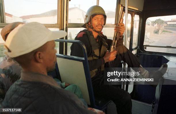 An armed private security guard keeps an eye on passengers and driver aboard a Golden Arrow bus in Khayelitsha, Cape Town 28 June 2000. Golden Arrow...