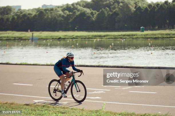woman training at outdoor velodrome - evento de ciclismo fotografías e imágenes de stock