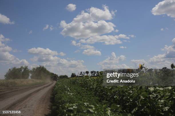Military vehicle passes by a sunflower field as Ukrainian artillery division supports soldiers in a counteroffensive on the Zaporizhzhya frontline...