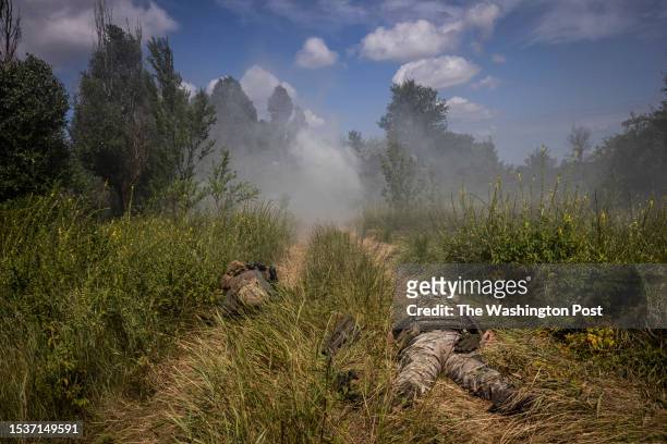 Soldiers duck as they clear an anti tank mine by using rope to remove the detonator during a mine clearance training exercise on July 11 2023, in...